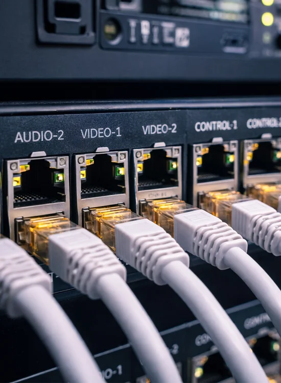 AV Network Switch and Structured Cabling Close-up of AV network switch with labeled ethernet ports and connected cables in equipment rack