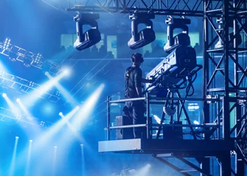 stage lighting rig installation Technicians installing stage lighting fixtures on overhead truss system