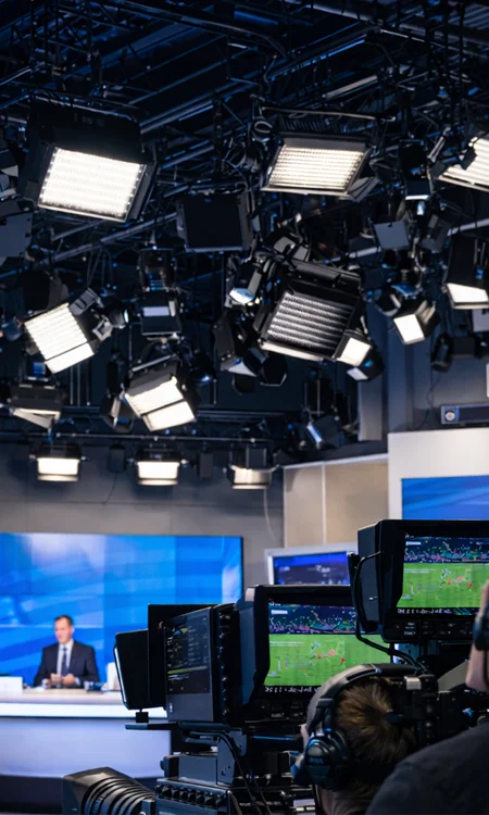 Broadcast studio lighting grid for video production studio lighting setup illuminating broadcast set with cameras and controlled lighting