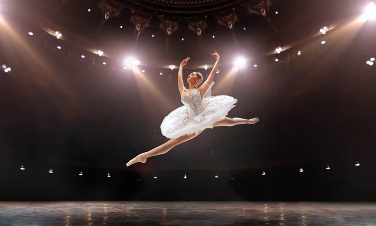 Ballet Performance Under Stage Lighting in Theater Ballerina performing on stage under theatrical lighting in a performing arts venue