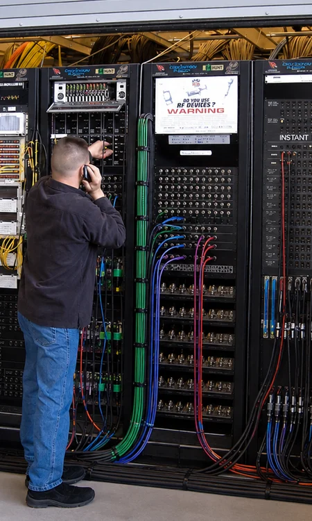 AV technician configuring equipment racks and structured cabling during training facility audio video system installation